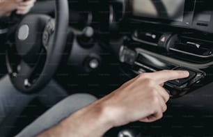 Cropped image of young man choosing a new vehicle in car dealership.