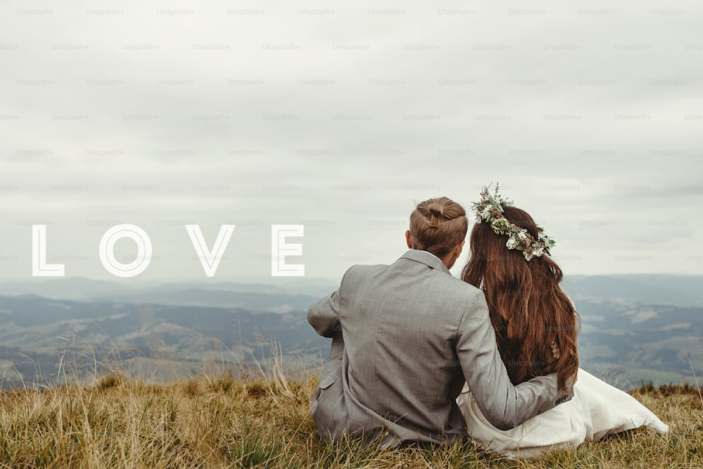 happy gorgeous bride and groom sitting on top of a mountain, perfect moment, boho wedding couple,love text