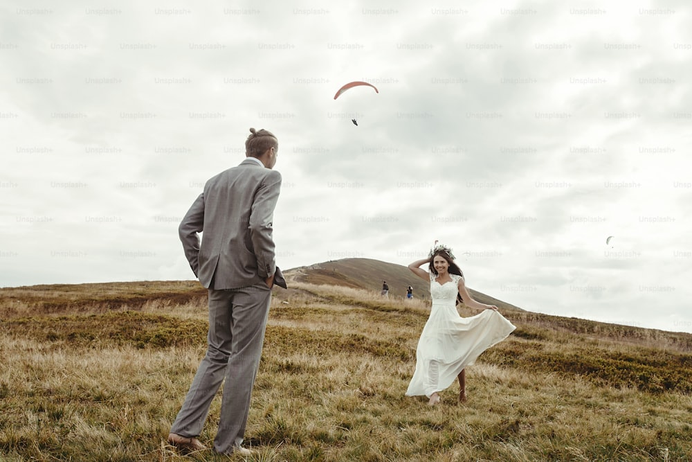 happy gorgeous bride running to groom and having fun, luxury ceremony at mountains with amazing view, space for text, boho wedding couple