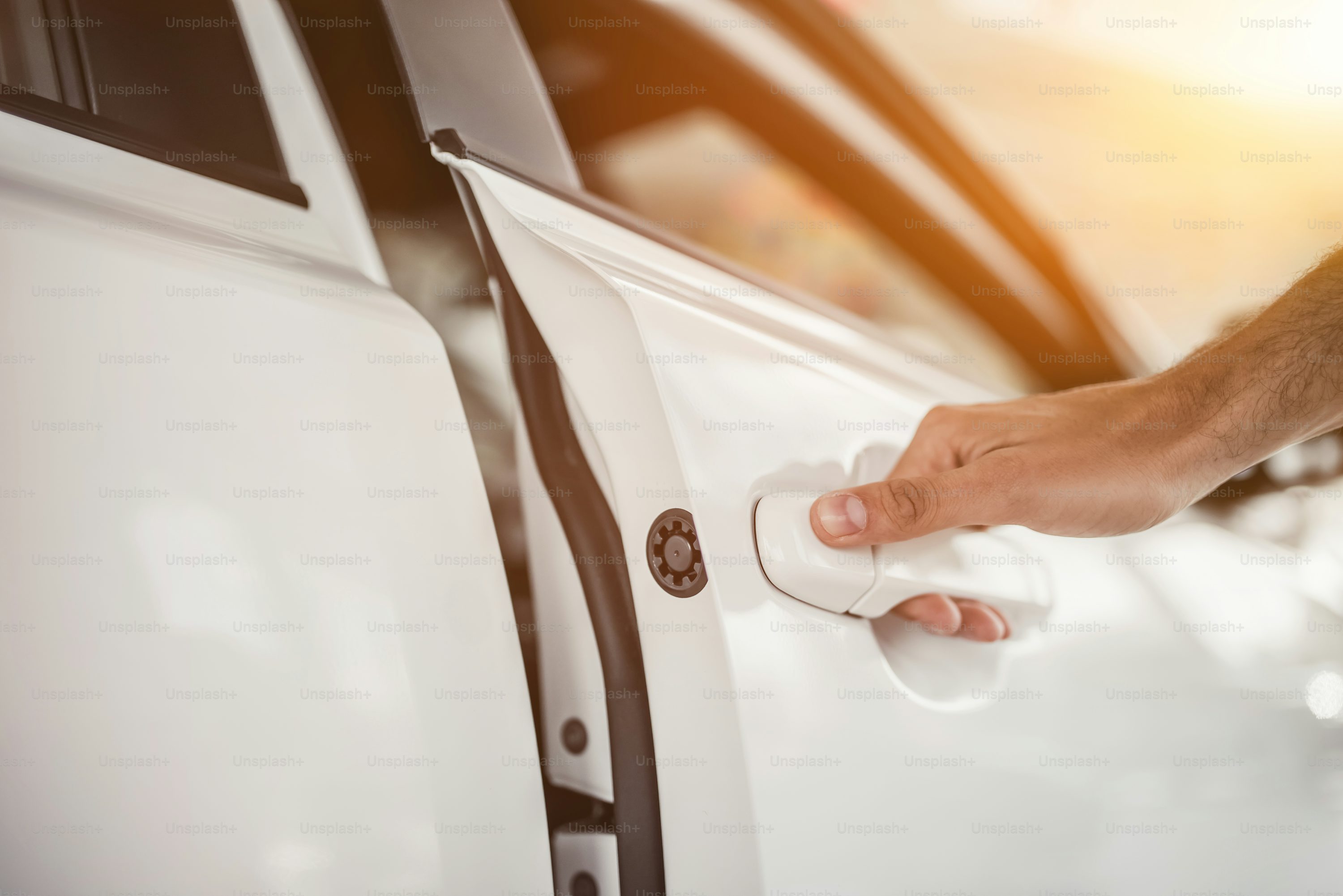 Cropped image of young man choosing a new vehicle in car dealership.