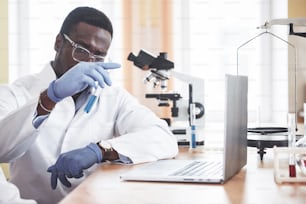 Um trabalhador afro-americano trabalha em um laboratório realizando experimentos