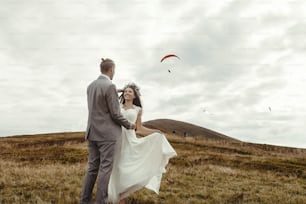 happy gorgeous bride running to groom and having fun, luxury ceremony at mountains with amazing view, space for text, boho wedding couple