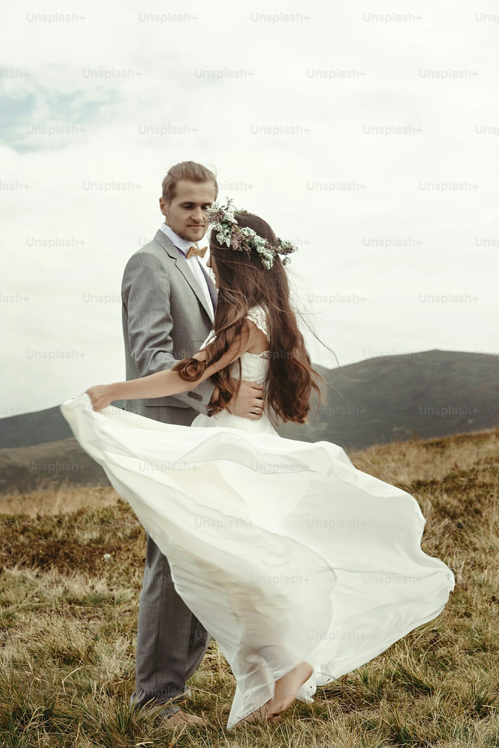 happy gorgeous bride and groom dancing on top of a mountain, luxury ceremony , space for text, boho wedding couple