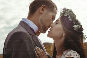 행복한 화려한 신부와 신랑 키스 태양 빛, 관능적 인 완벽한 순간, boho 결혼식 커플, 산에서 호화로운 의식
