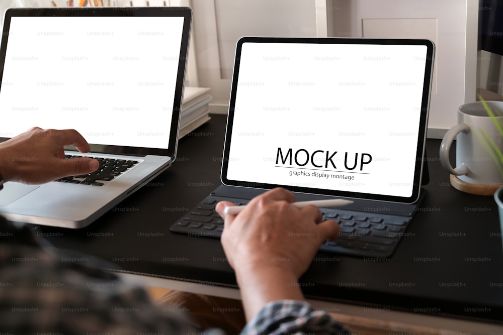 Man using tablet and laptop at workspace, Blank screen laptop and tablet