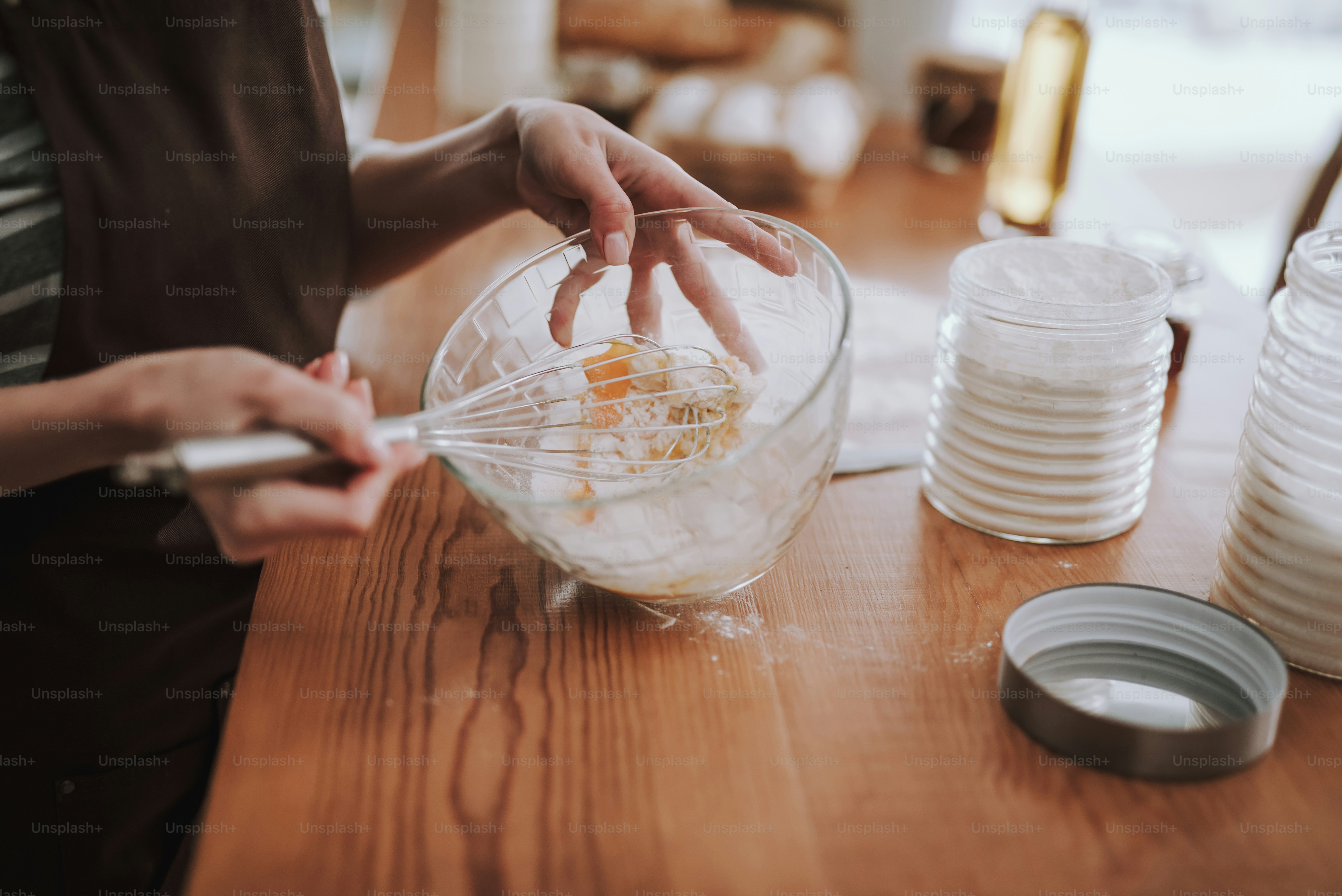 Focus on housewife preparing bakery in kitchen. She is mixing ...