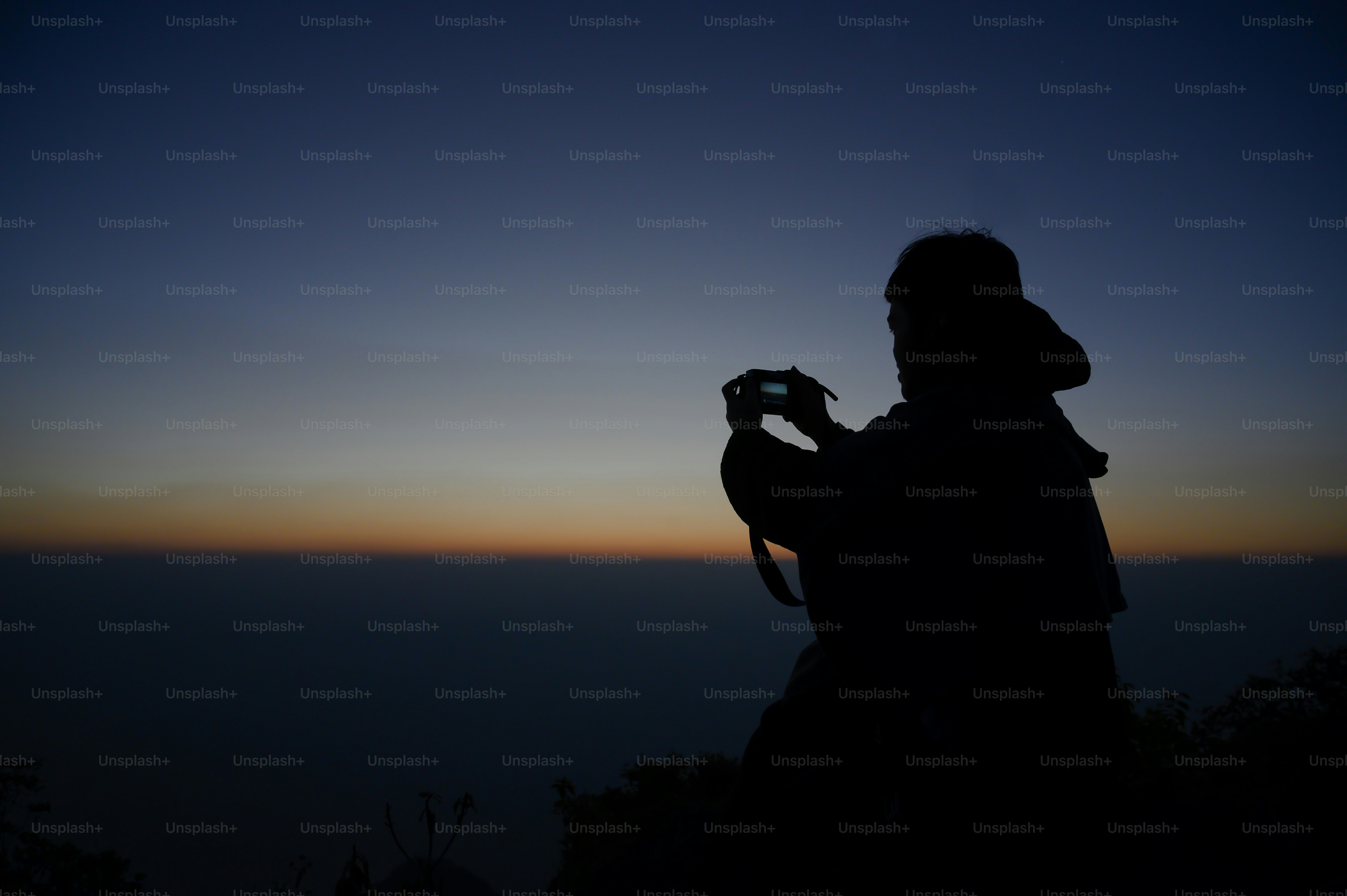 Photographer Taking Pictures On Mountain view with silhouette sunrise.