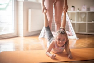 Exercises are best with your mother's help. Mother and daughter working exercise.