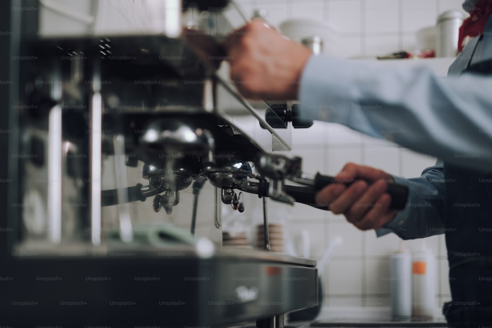 I need fresh espresso. Close up of male hands checking coffee maker