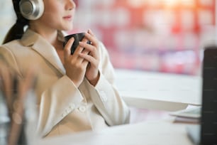 Businesswoman holding a coffee cup and listening a music relax feeling.