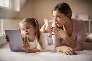 O que as crianças de hoje estão procurando on-line? Meu Deus. Mãe e filha usando tablet digital.