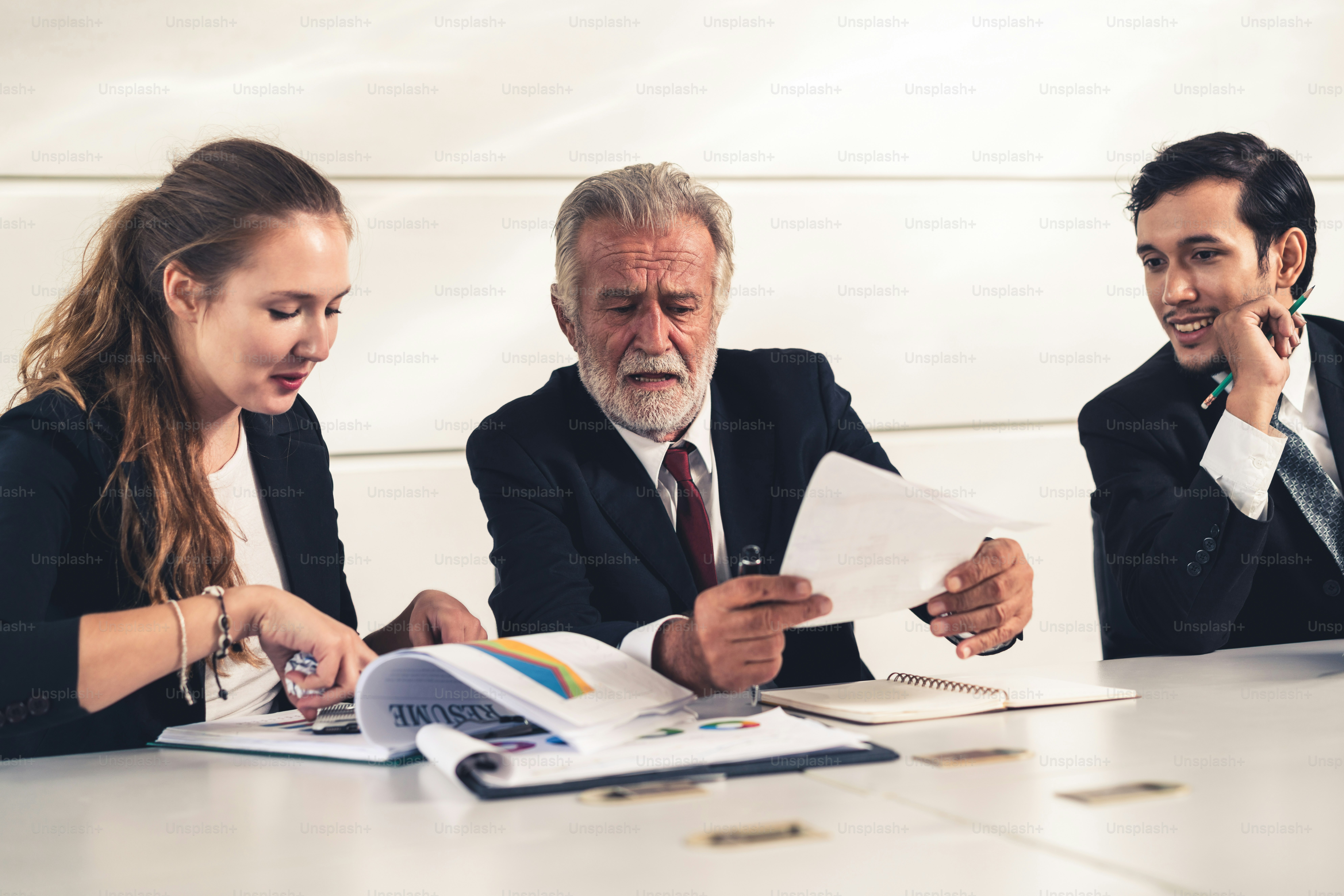 Senior old executive manager working with young businesspeople in ...