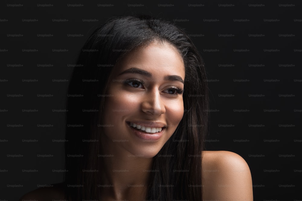 Portrait of appealing woman with nude shoulders and sleek skin. She is laughing. Isolated on background
