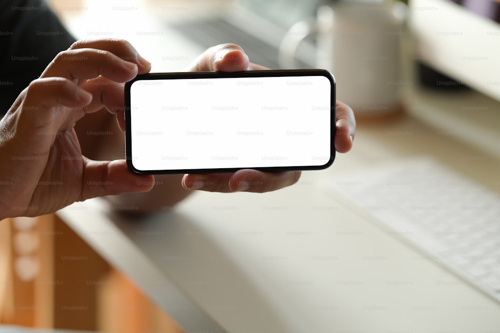 Man showing blank screen mobile phone at office