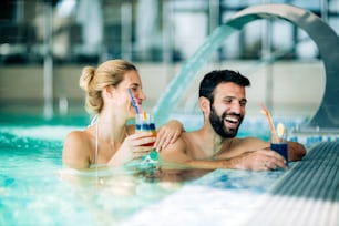 Glückliches attraktives Paar, das sich im Spa-Pool entspannt