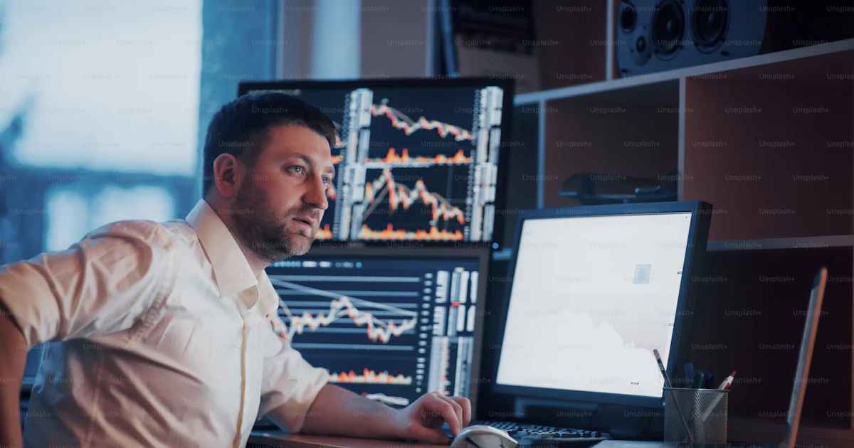 Busy working day. Close-up of young businessman looking at monitor ...