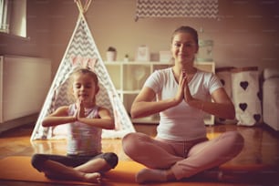 Be calm. Mother and daughter working exercise.