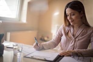 The signature is a seal on the contract. Business woman working at home.