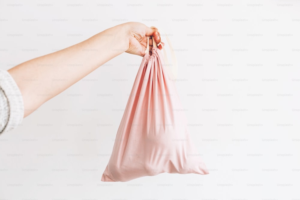 Vietare la plastica monouso. Donna che tiene in mano la spesa in un sacchetto ecologico riutilizzabile. Concetto di shopping Zero Waste. Scegli borse naturali ecologiche. Stile di vita sostenibile. Riutilizzare, ridurre, rifiutare