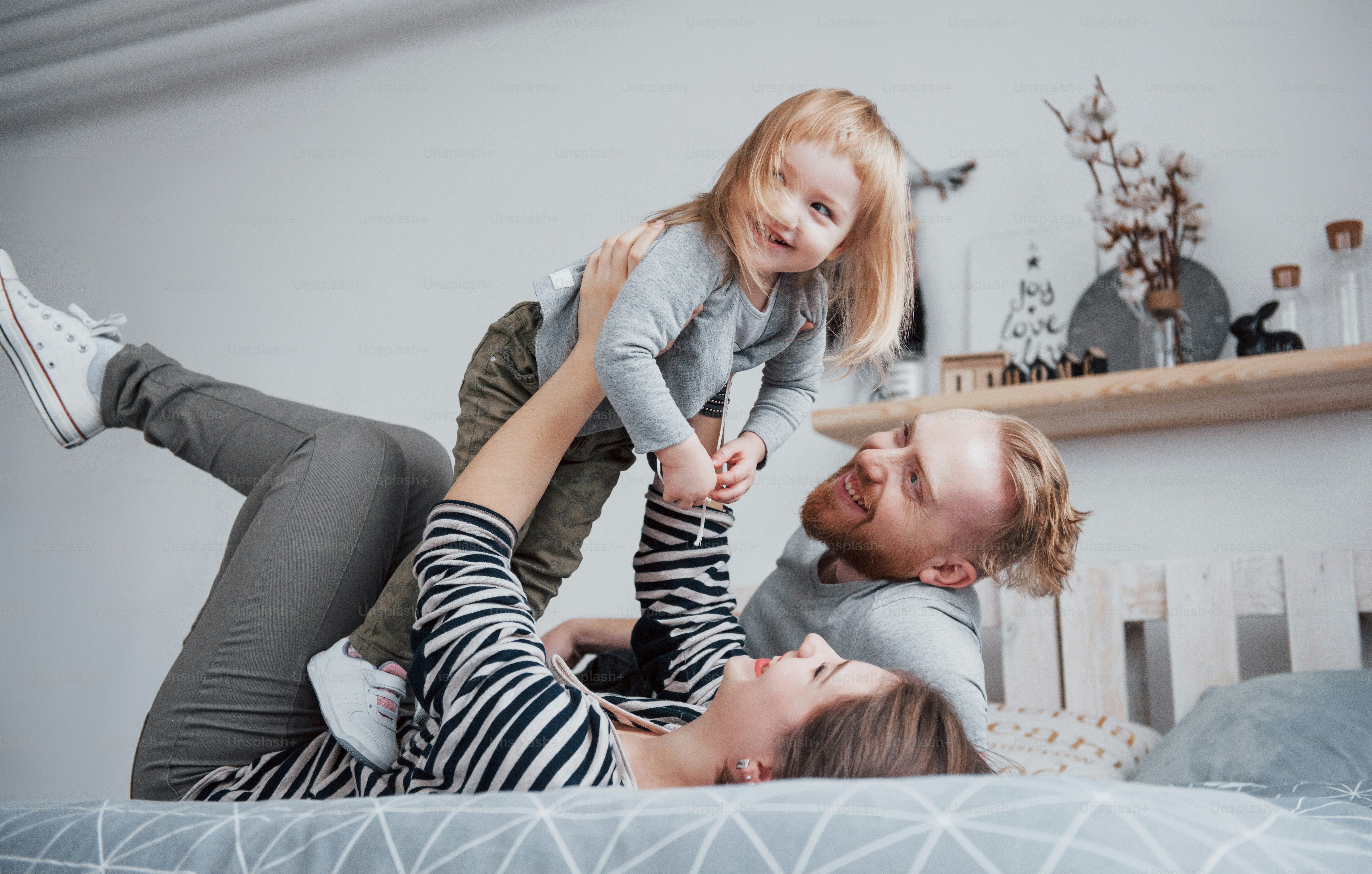 Familia feliz madre, padre e hija hija se ríe en la cama. foto – Imagen ...