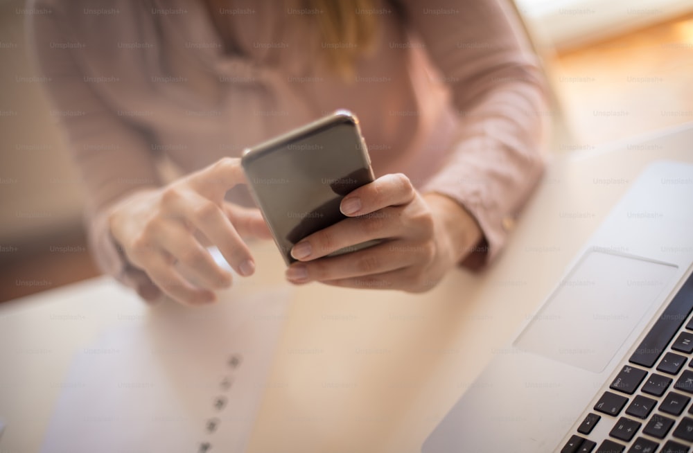 Little help. Business woman using smart phone. Close up. Focus on hands.