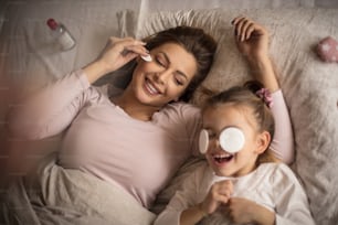 Be a fresh at the morning. Mother and daughter playing on bed.