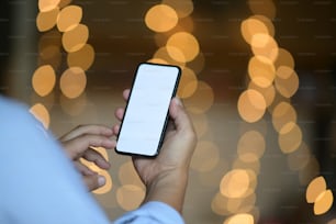 Man hand holding mobile smartphone with blur bokeh background