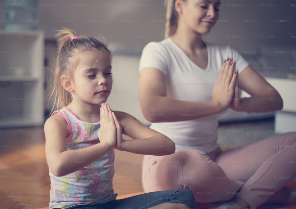 Para la paz y la relajación, el yoga es el mejor ejercicio. Madre e hija trabajando yoga.