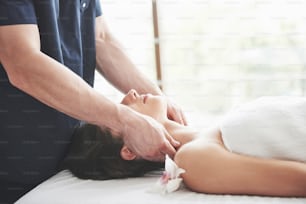 Masseur makes relaxation massage for a neck for a woman