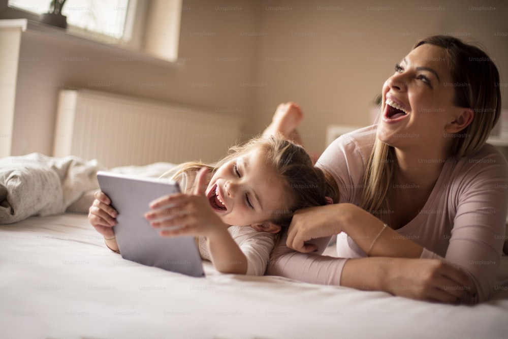Viel Spaß mit Technik. Mutter und Tochter mit digitalem Tablet.
