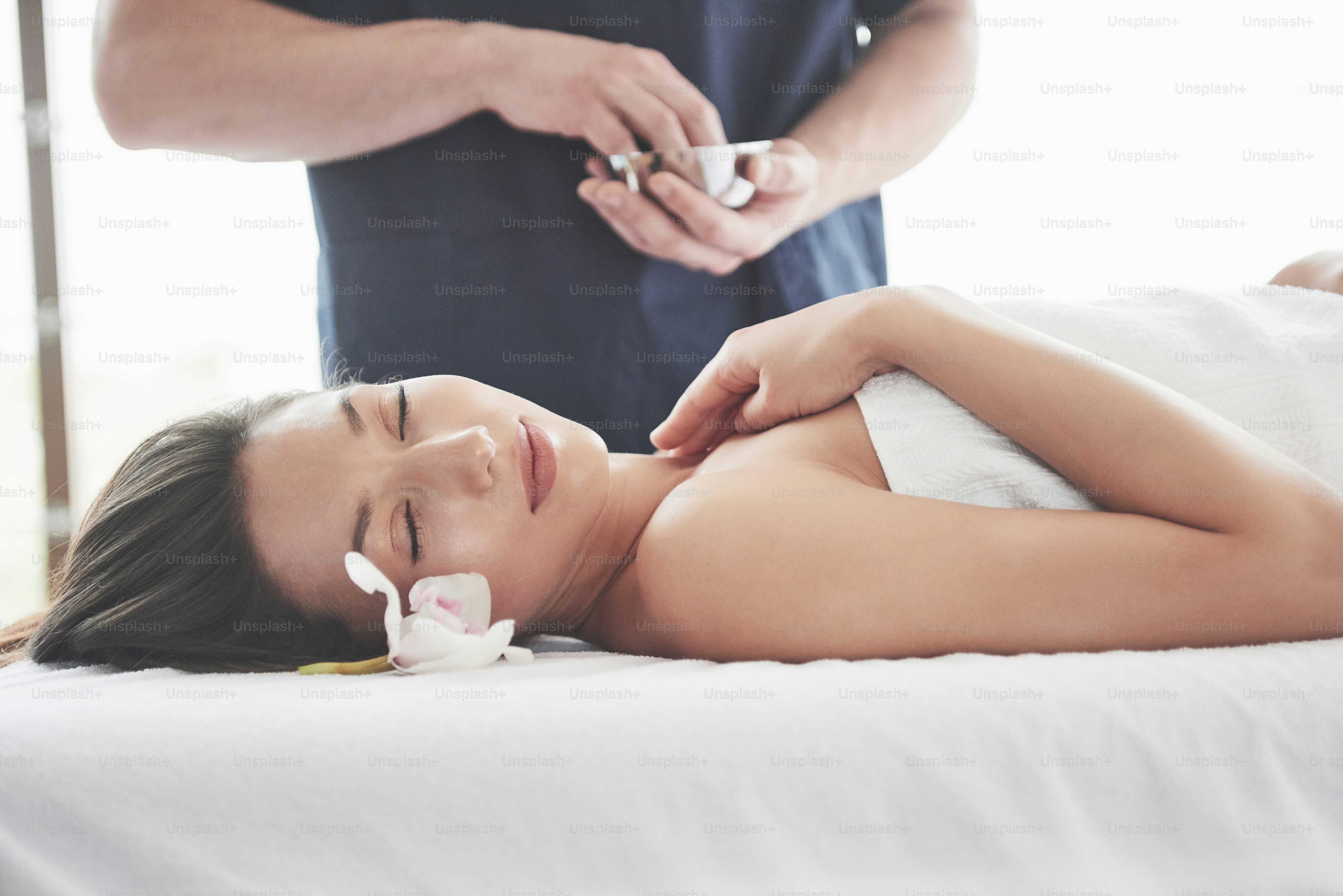 Wanita cantik berbaring di meja pijat di Spa