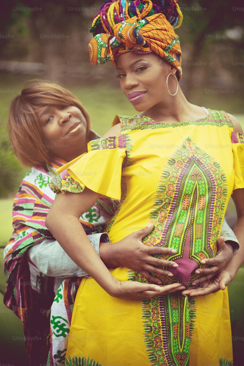 Não estou sozinho nesta viagem. Mulher grávida afro-americana no parque com sua mãe.