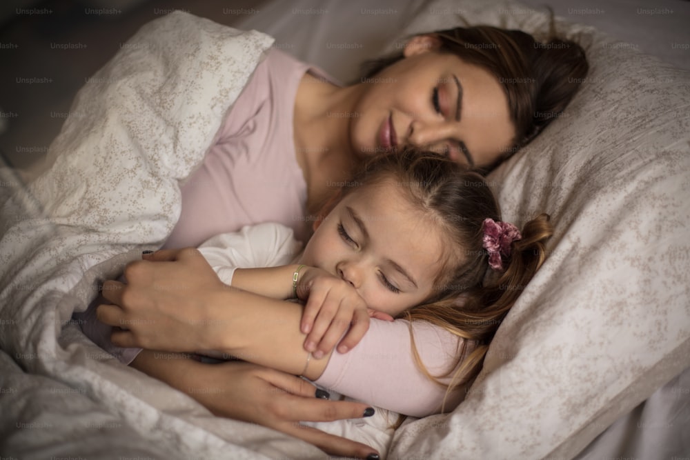 Mom's hug is the most beautiful. Mother and daughter sleeping together.