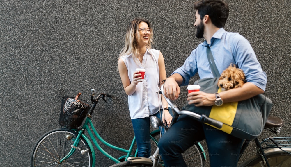 도시에서 화창한 날에 자전거를 타러 가는 행복한 젊은 커플