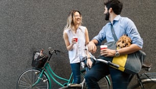 Giovane coppia felice che va a fare un giro in bicicletta in una giornata di sole in città