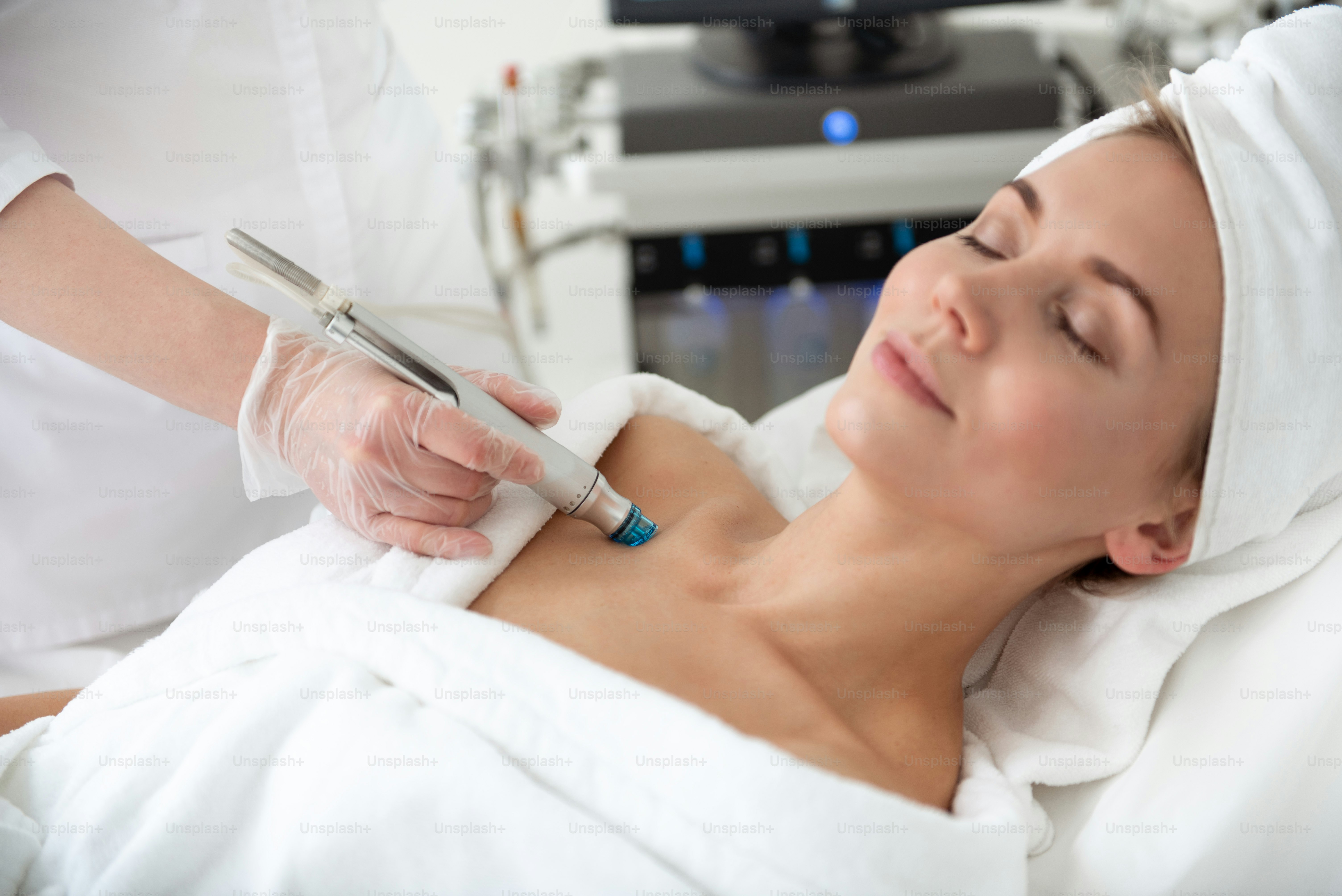 Outgoing lady having pleasure while getting rejuvenating facial massage in beauty clinic