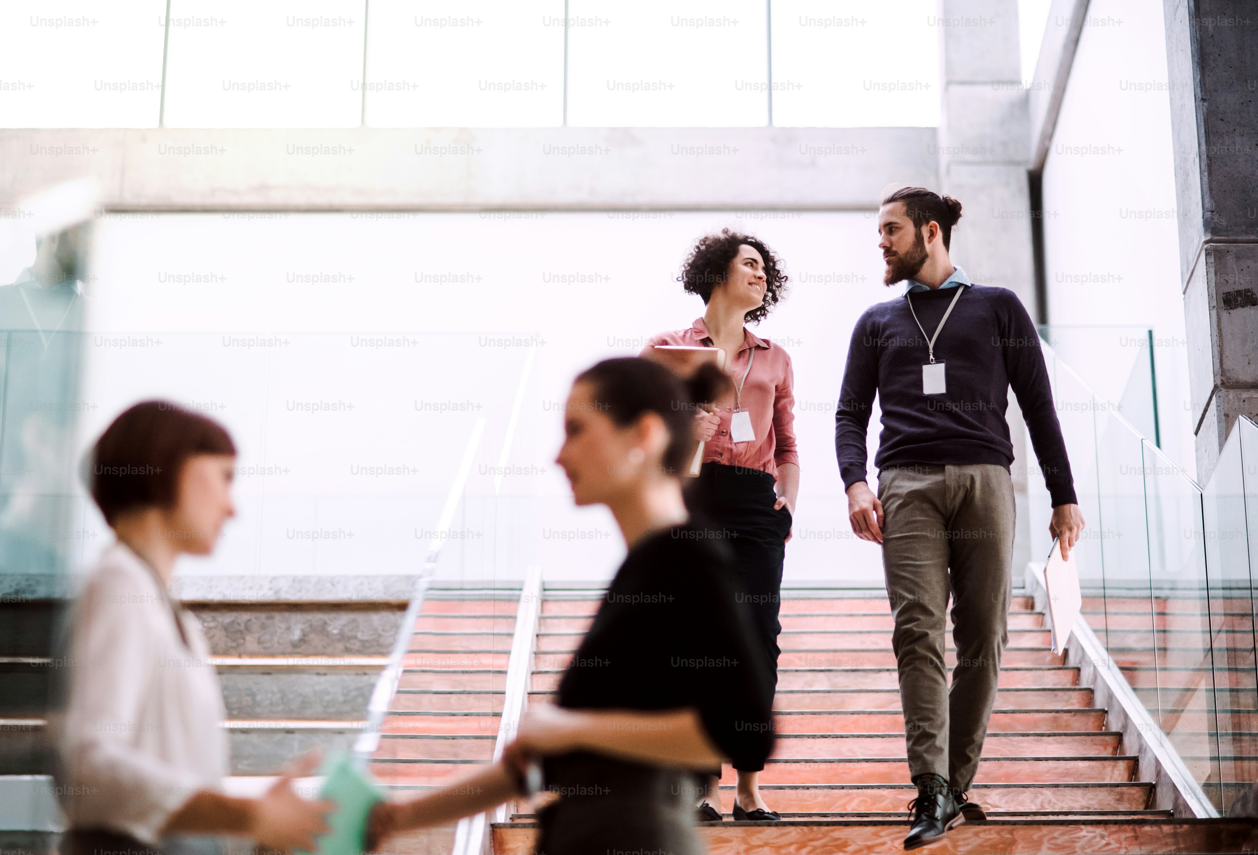 A group of young businesspeople talking by a staircase.