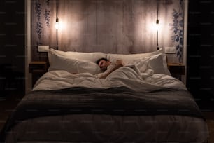 Mann schläft im Bett in einem modernen schönen Schlafzimmer
