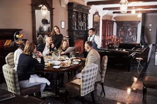 Todo es perfecto en esa habitación. Amigos de la familia pasando un buen rato en un hermoso restaurante moderno de lujo.