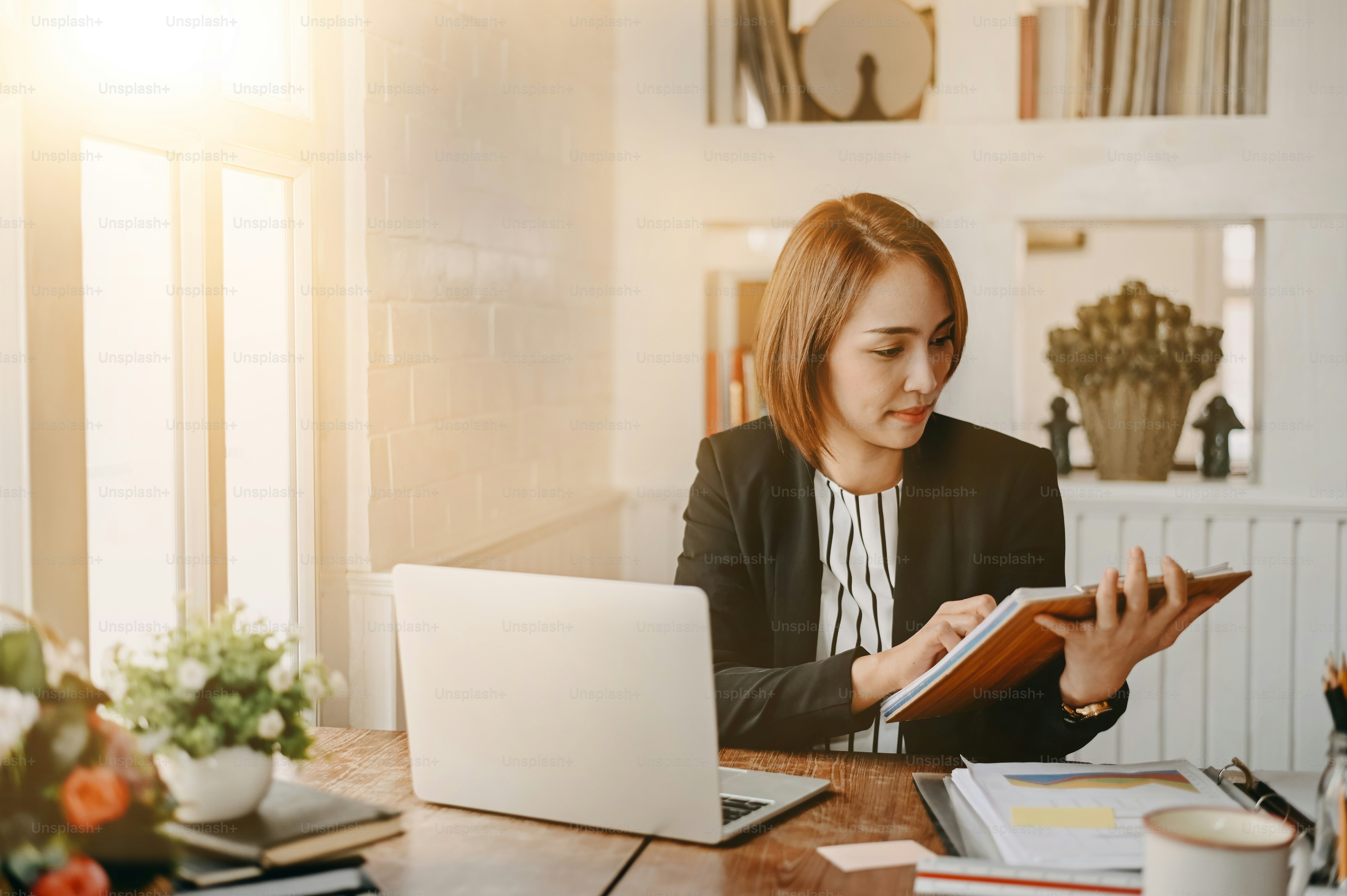 Businesswomen checklist on board and working on office desk.