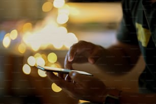 Man using his cellphone in walking street and  bokeh lights