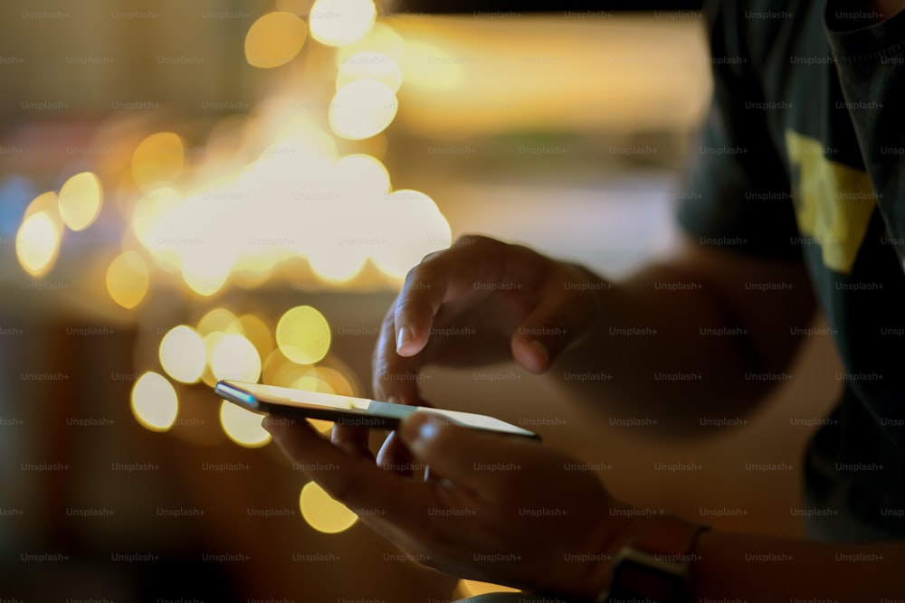 Man using his cellphone in walking street and  bokeh lights