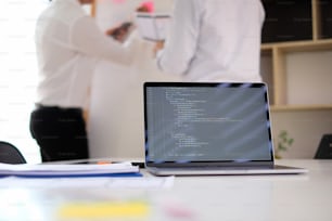 Laptop computer showing a coding program in programer studio meeting room.