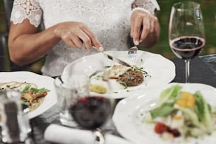 Une femme coupe de la nourriture sur des tranches. La nourriture végétale est sur la table du restaurant extérieur ou du restaurant extérieur.