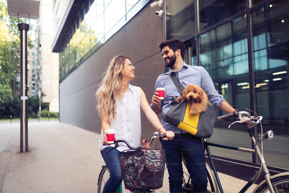 Attractive woman and handsome man spending time together with dog and bicycles
