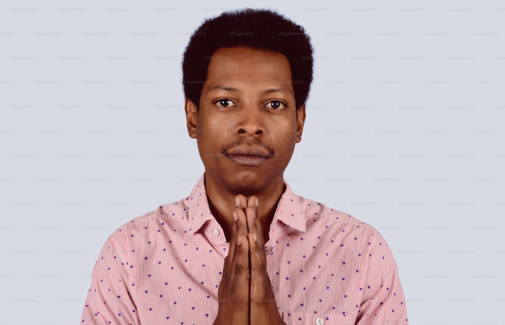 Portrait of Afro American man praying on studio.