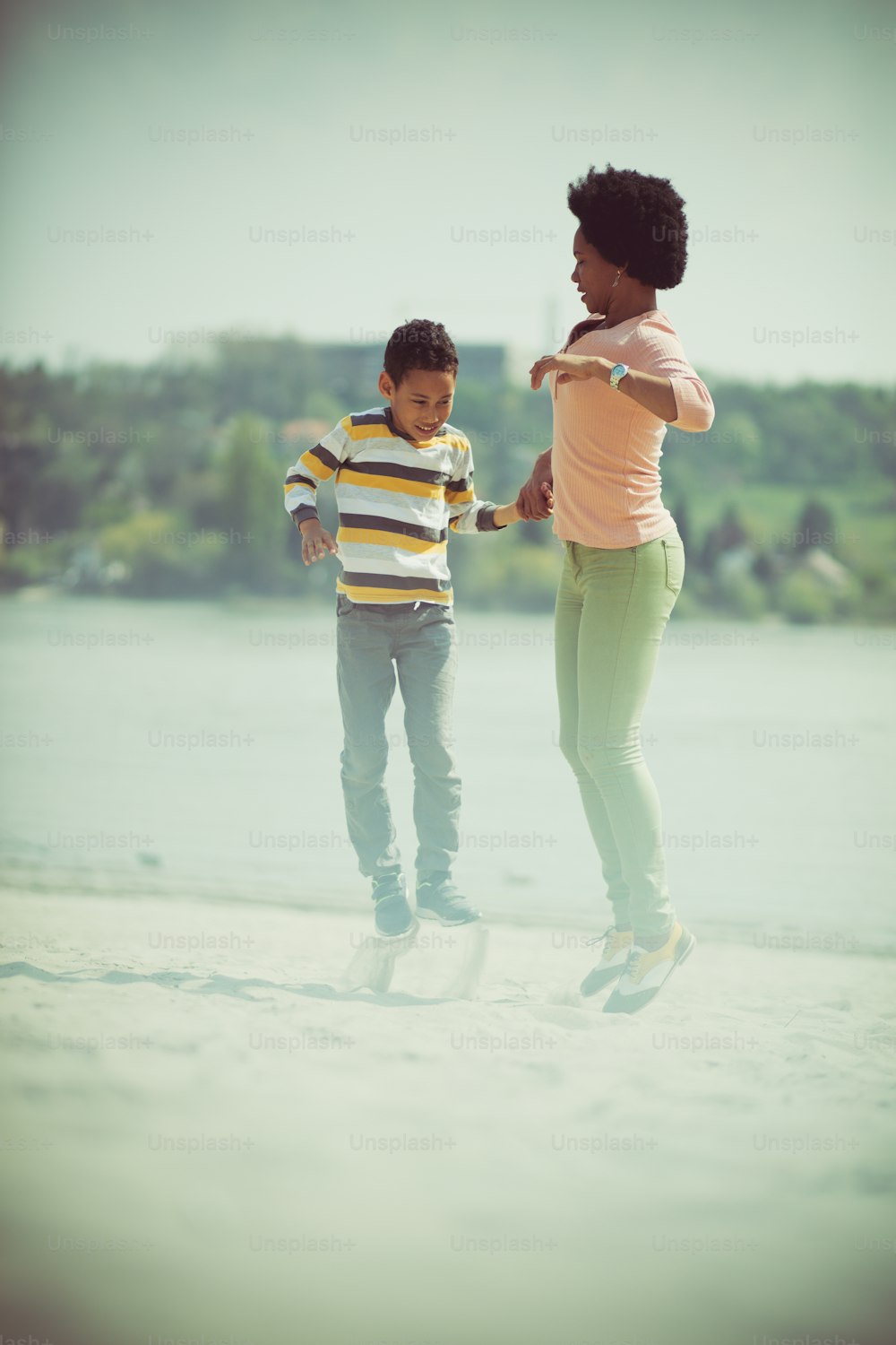 Jump an be happy. Mother and son on the beach.