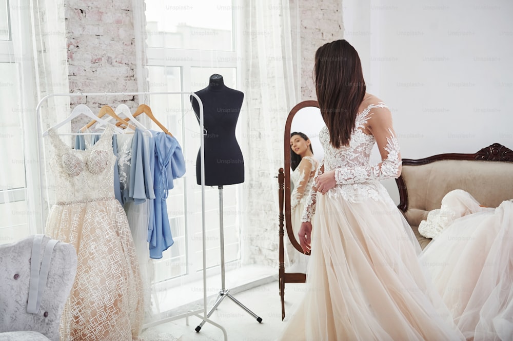 見た目が気に入っています。手作りの服のスタジオでドレスをフィッティングするプロセス。