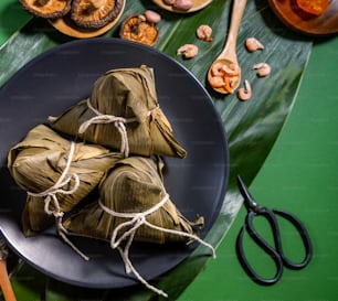 Close up, copy space, top view, flat lay. Famous asian chinese tasty handmade food in duan wu festival, steamed rice dumplings shaped like pyramidal ingredients