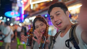 여행자 아시아 블로거 커플은 태국 방콕을 여행하고, 휴대 전화를 사용하는 달콤한 커플은 카오산로드에서 행 아웃을하면서 브이로그를 만들고 소셜 미디어에 살고 있습니다. 태국 개념에서 커플 여행.